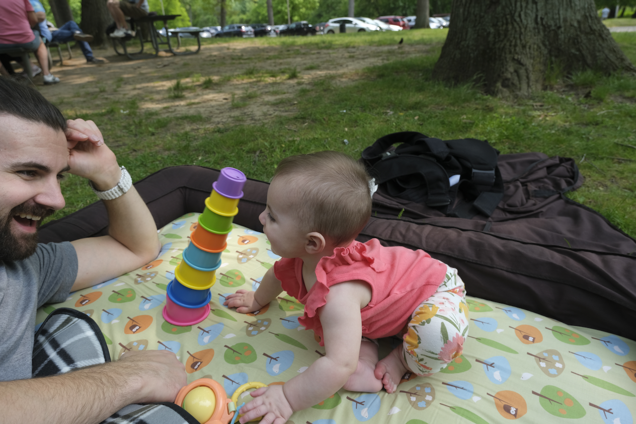 Zoe knocking over her stacking cups in the park.