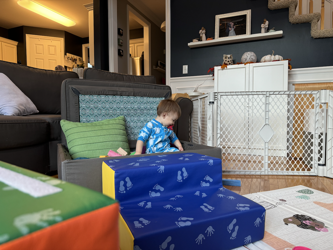 Zoe sitting in her ottoman fort.