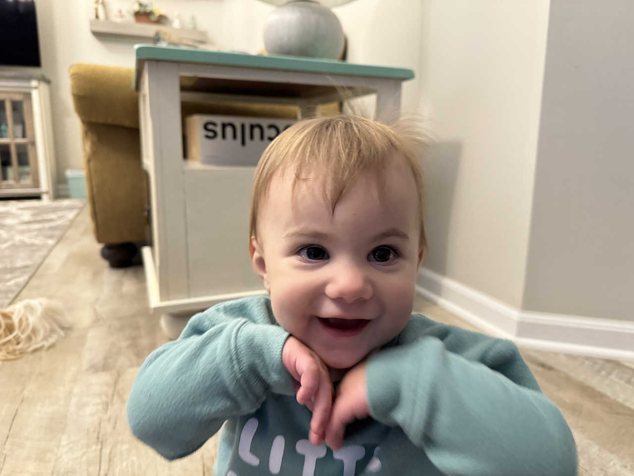 Zoe resting her head on her hands and giving a joyful smile.